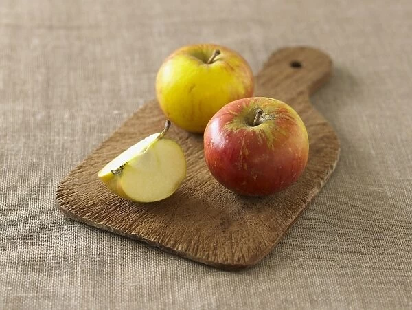 Coxs Orange Pippin apples on chopping board, whole and slice