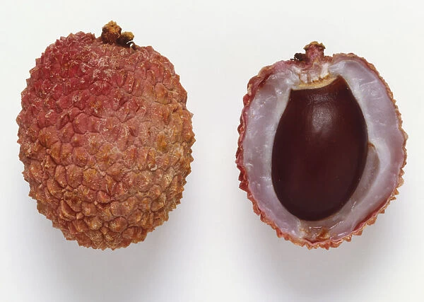 Cross section through a lychee, Chinese fruit with thin red brittle shell enclosing a sweet white fruit and a single seed