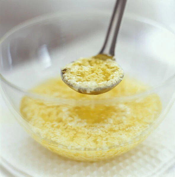 Curdled mayonnaise in glass mixing bowl and on ladle