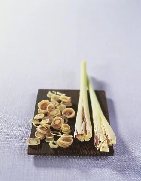 Cymbopogon citratus, Lemon Grass, bruised fresh stalks, and finely cut slices on wooden board