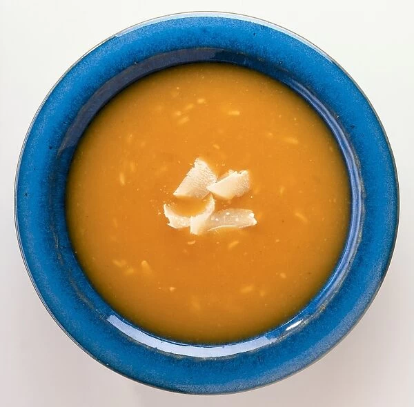 Deep yellow pumpkin soup in a blue bowl