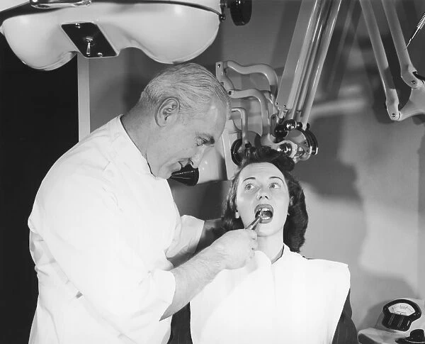 Dentist pulling womans tooth