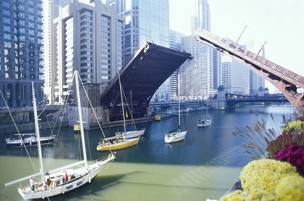 Drawbridge spanning the Chicago River opening for water traffic