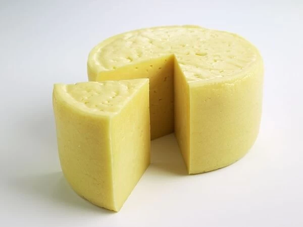 Drum and slice of Swedish Hushallsost cows milk cheese