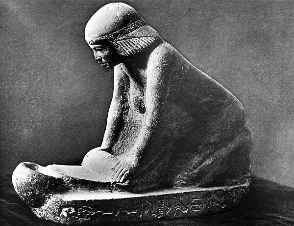 Egyptian woman grinding corn using a saddle quern. Egyptian tomb figure c 2, 500 BC
