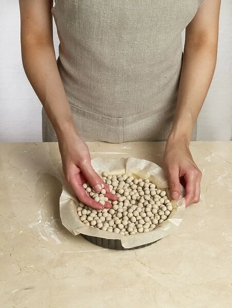 Filling a tart tin with baking beans