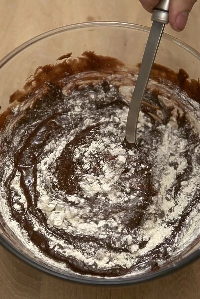 Folding in the flour to a chocolate mixture