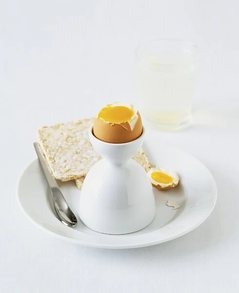 Free-range hard boiled egg served with rice cakes and glass of hot water with juice of lemon