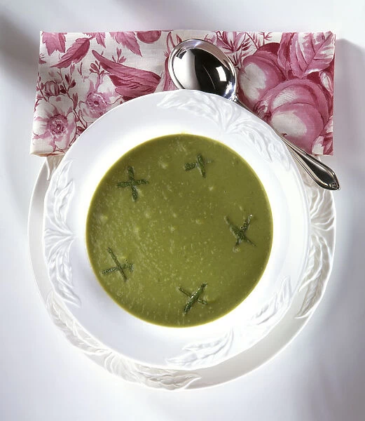 French Pea Soup served in white bowl, garnished with fresh mint