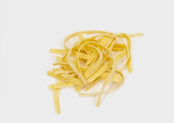 Fresh egg tagliatelle pasta on white background