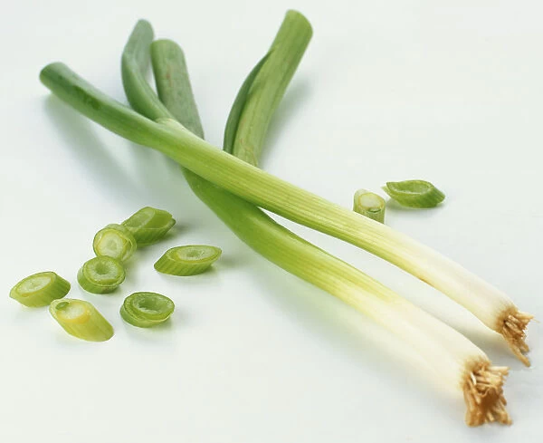 Two fresh whole spring onions, and discs of sliced green shoot
