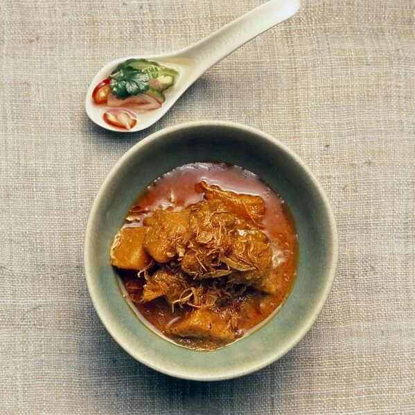 Geng gari fak tong, Thai pumpkin curry garnished with deep-fried shallots, cucumber relish in spoon