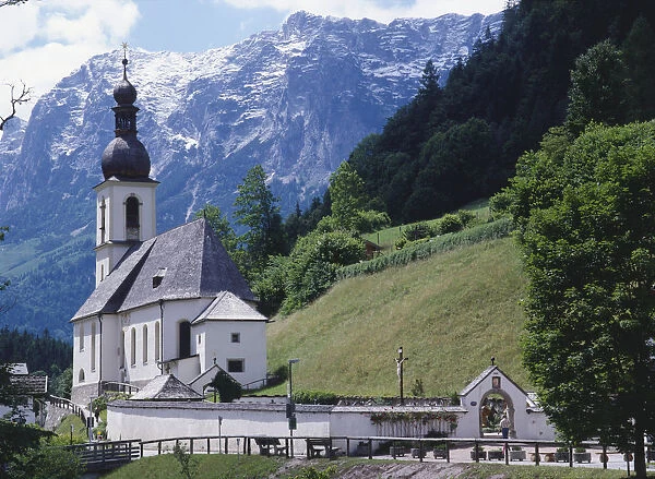Germany, Bavaria, Berchtesgadener Land region, Ramsau an der Ache, small parish church set in the Ramsau Valley with snow-capped mountains as a backdrop