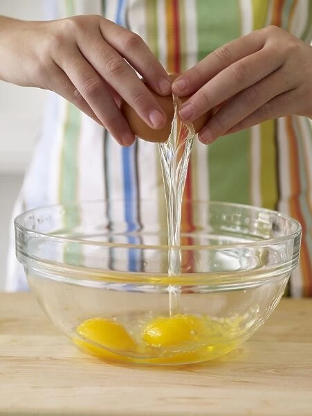 Girls hands breaking egg into bowl, close-up