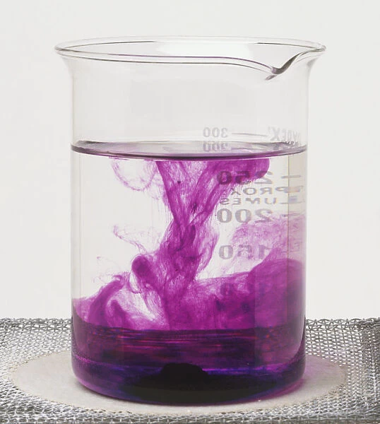 Glass beaker containing potassium manganate shows the solid dissolving to form a solution