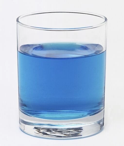 A glass filled with a blue liquid