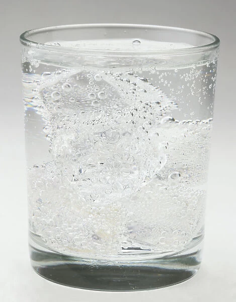 Glass of fizzy water and ice cubes