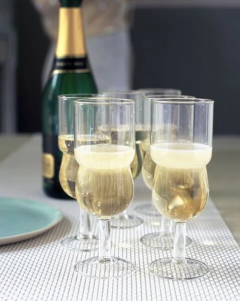 Glasses of champagne with champagne bottle in the background