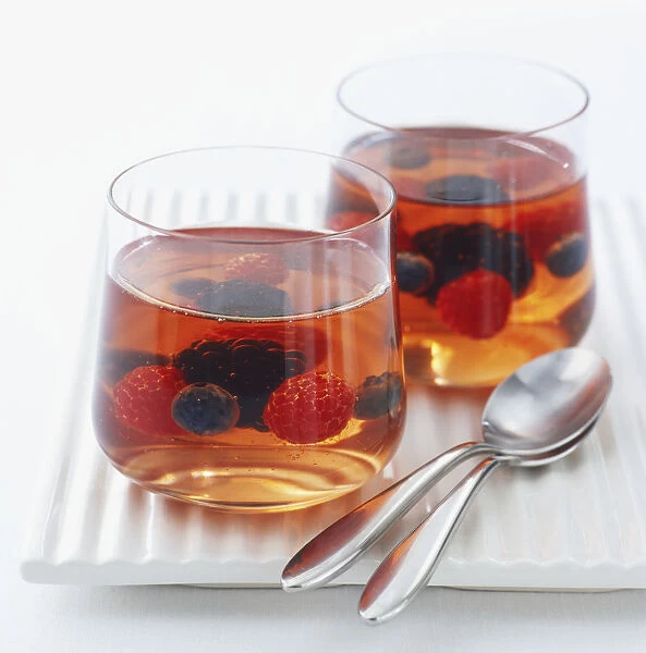 Two glasses of rose wine jelly with berries