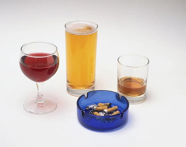 Glasses of wine, beer, and whisky and an ashtray containing cigarette butts