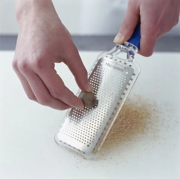 Grating nutmeg with microplane grater, close-up