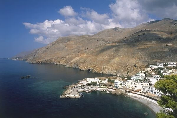 Greece, Crete, aerial view of Sfakia harbour, houses nestling above, rolling hills surrounding
