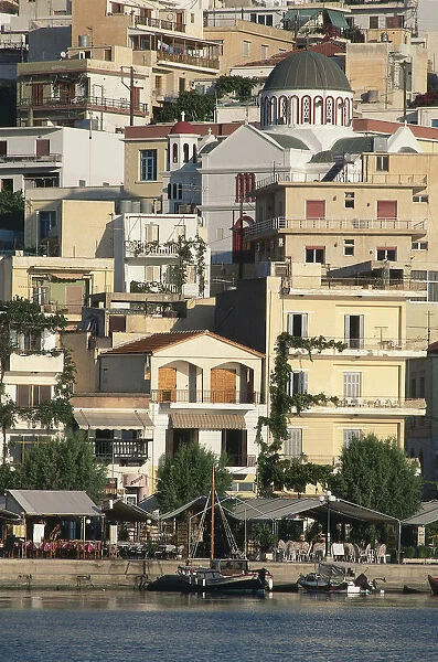 Greece, Crete, Siteias old quarter, clustered houses on hillside overlooking tree-lined harbour