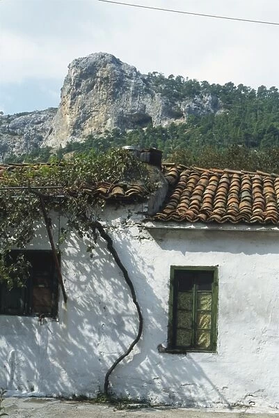 Greece, Evvoia, Steni, Mount Dirfys seen behind traditional whitewashed house