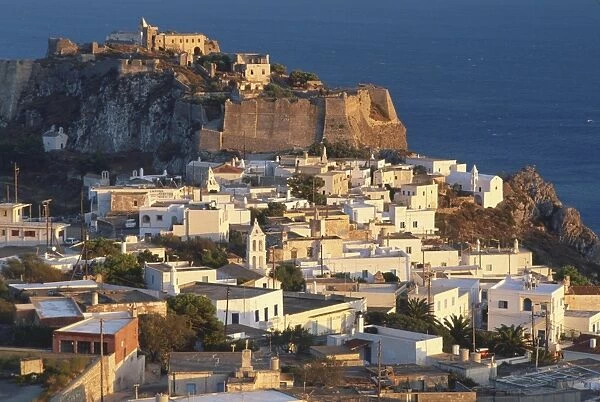 Greece, Kythira, Chora at dusk, houses clustered on hillside, ruins on clifftop