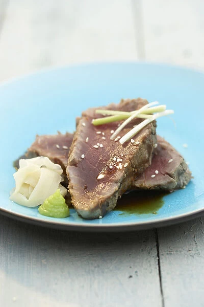 Grill-seared double-thick tuna steaks with pickled ginger, wasabi and soy sauce, served on blue plate