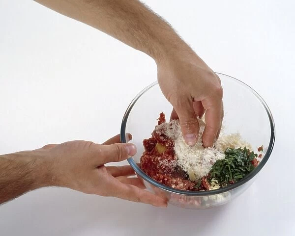 Hand mixing together meatball ingredients, minced beef, parsley, parmesan cheese and an egg in a glass bowl