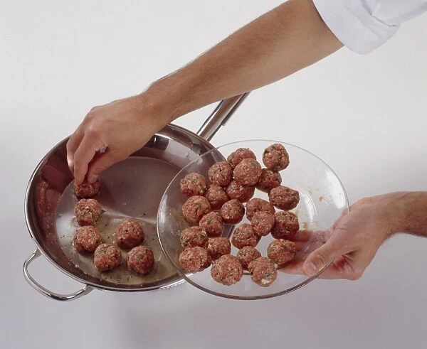 Hand placing meatballs into frying pan from glass plate, close-up