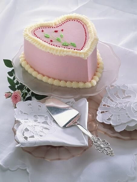 Heart-shaped cake decorated with pink icing and frosting, serviettes on plates, roses, white table cloth, cake slice, close up