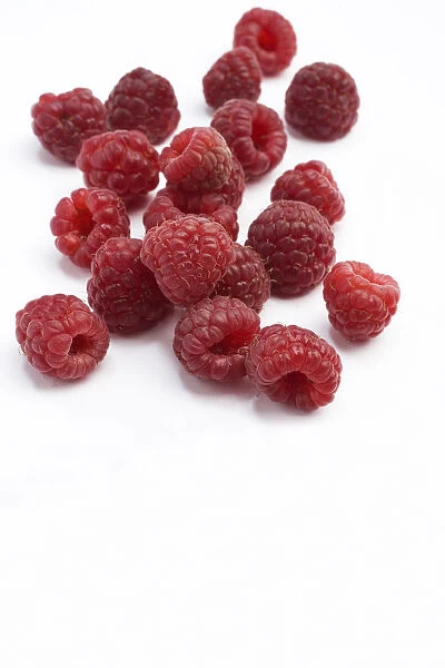 Heritage red raspberries on white background, close-up
