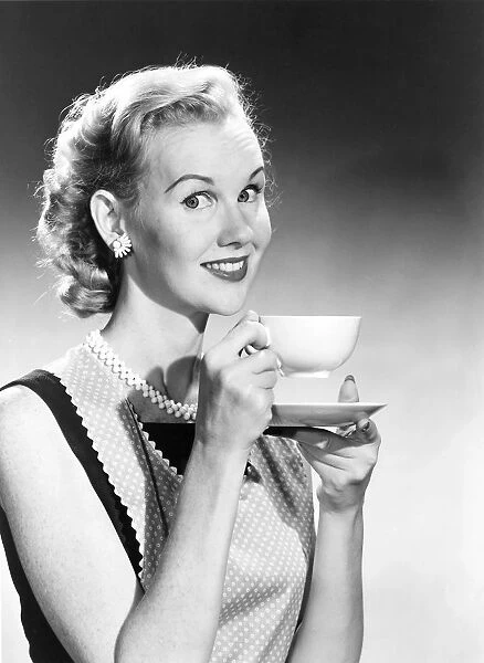 Housewife in pearls and apron drinks coffee