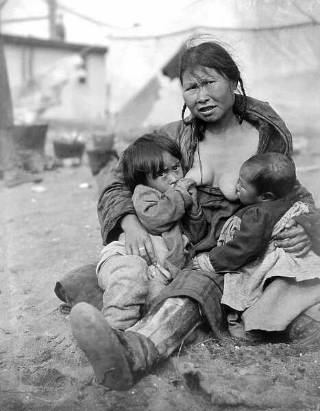 An Inuit Eskimo woman breast-feeding two babies