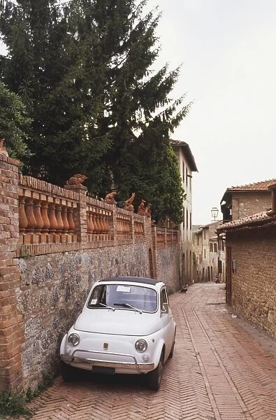 Italy, Central Tuscany, San Gimignano, old Fiat 500 parked by wall in back street