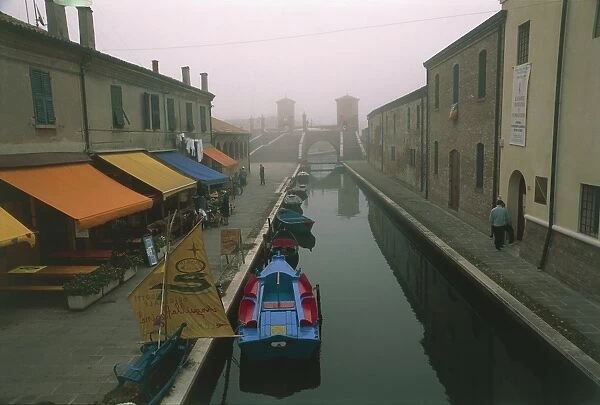 Italy, Emilia-Romagna Region, Comacchio (Ferrara Province), Po Delta Regional Park, Coloured batana boats along canal