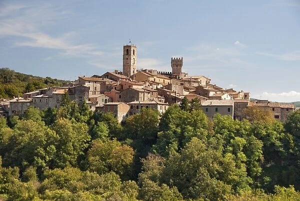 Italy, Tuscany, San Casciano dei Bagni, crowded buildings of village on top of hill surrounded by trees
