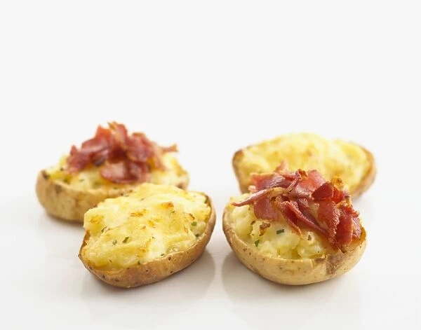 Jacket potato halves with cheese and bacon toppings
