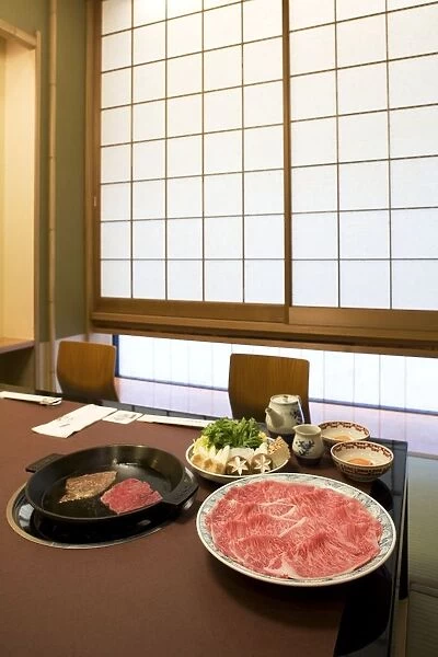 Japan, Tokyo, beef sukiyaki and side dishes laid out on restaurant table
