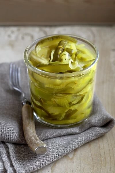 Jar of cucumber pickle with fork and napkin, close-up