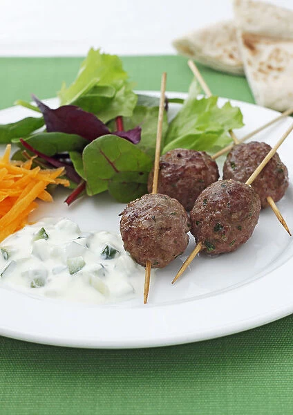 Koftas with salad and dip on plate, close-up