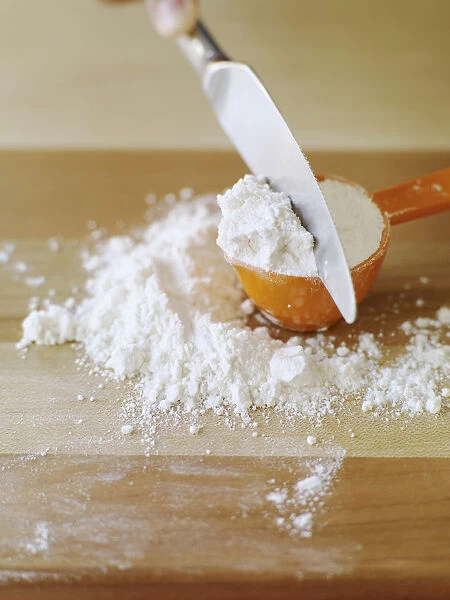 Levelling measuring cup of flour with back of knife