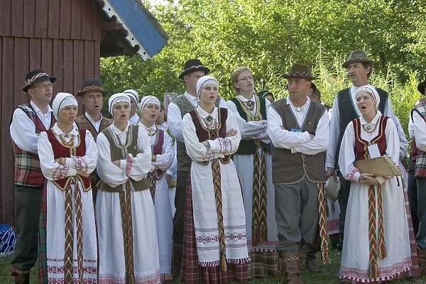 Lithuania, Klaipeda County, Curonian Spit, Nida, people wearing traditional costumes singing outside house