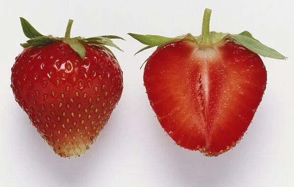 Longitudal section through a strawberry beside a whole strawberry