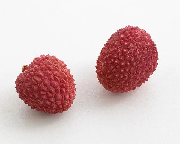 Two lychees on white background