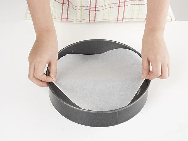 Making cheesecake, lining cake tin with wax paper