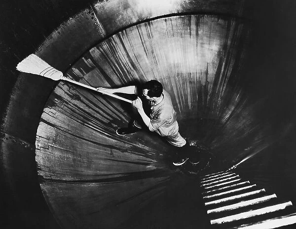Man cleaning inside of huge kettle at brewery, Wisconsin