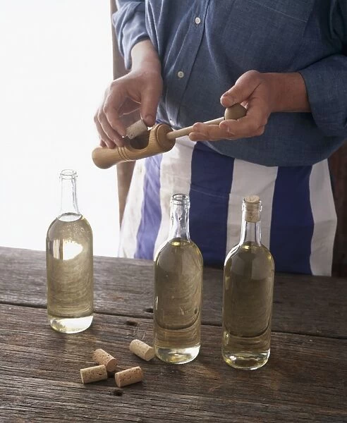 Man corking bottles of home-made wine